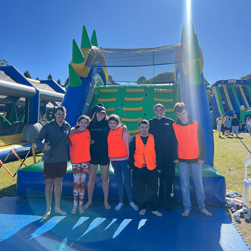 A group of people standing together at the bottom of an inflatable slide